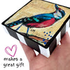 a hand holding up a bird art block painting  with a white background and the text makes a great gift'