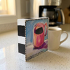 Coffee art block with pink mug artwork, ‘Coffee is NOT optional’ text and black-and-white painted edges, beside a mug and coffee maker