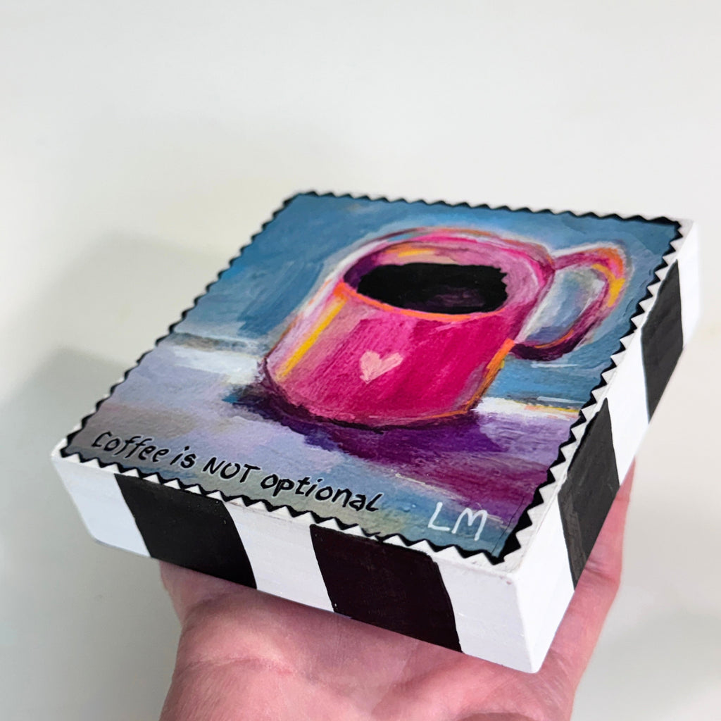 block of wood with artwork of a cup of coffee with a heart on it