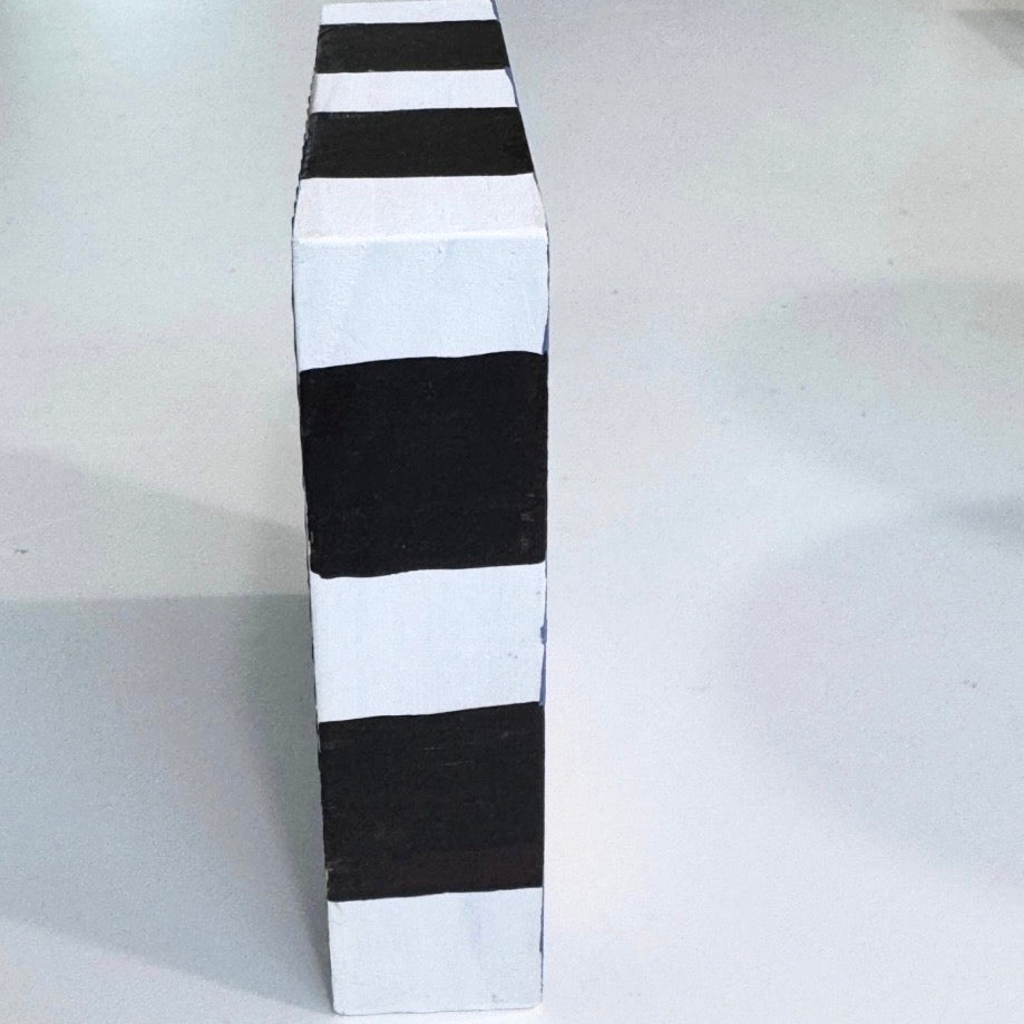 Side view of Coffee wooden art block showing two broad black painted bands on a white edge