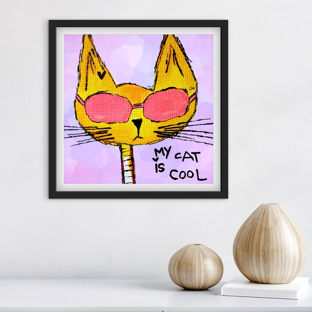 Framed artwork of a cat wearing sunglasses with 'My cat is cool' text on a purple background, displayed on a white wall.