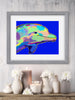 Framed colorful dolphin artwork on a wall above a decorative shelf with candles and vases.
