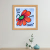 Framed artwork with a red flower and motivational quote on a white wall.