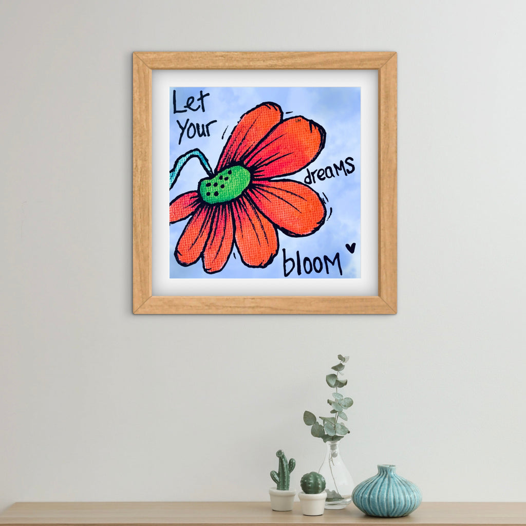 Framed artwork with a red flower and motivational quote on a white wall.