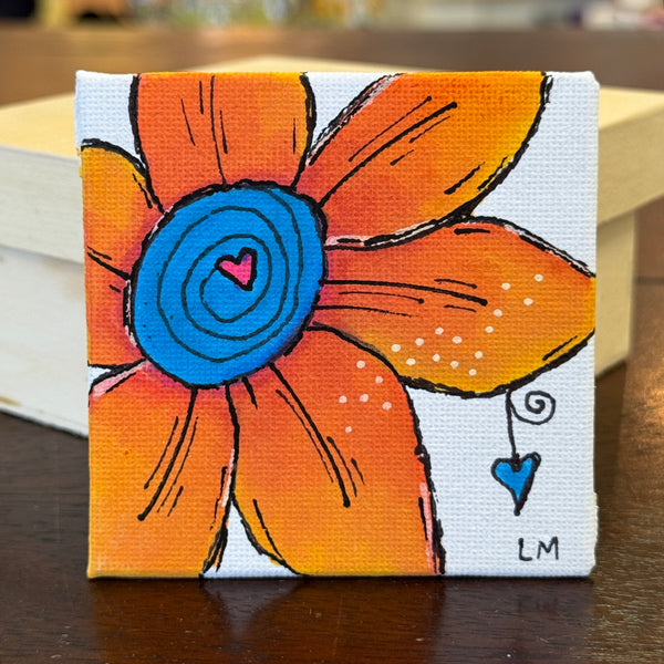 orange flower with blue heart center and a heart dangling off a petal
