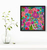 floral painting with black frame on a white wall next to a vase