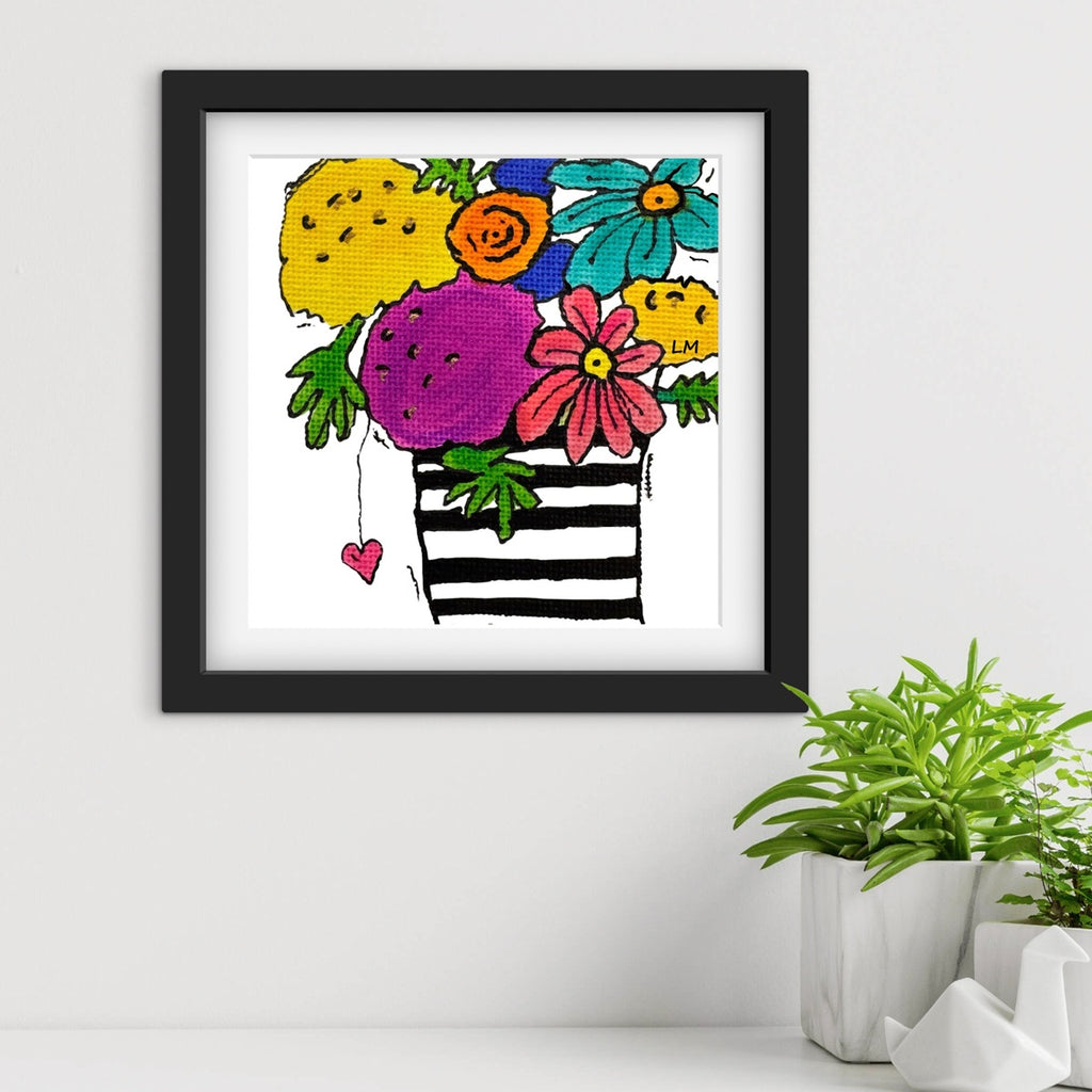 Framed artwork with colorful flowers and a striped vase on a white wall.