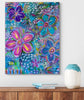 Colorful floral painting on a wall above a wooden shelf with a vase and books.