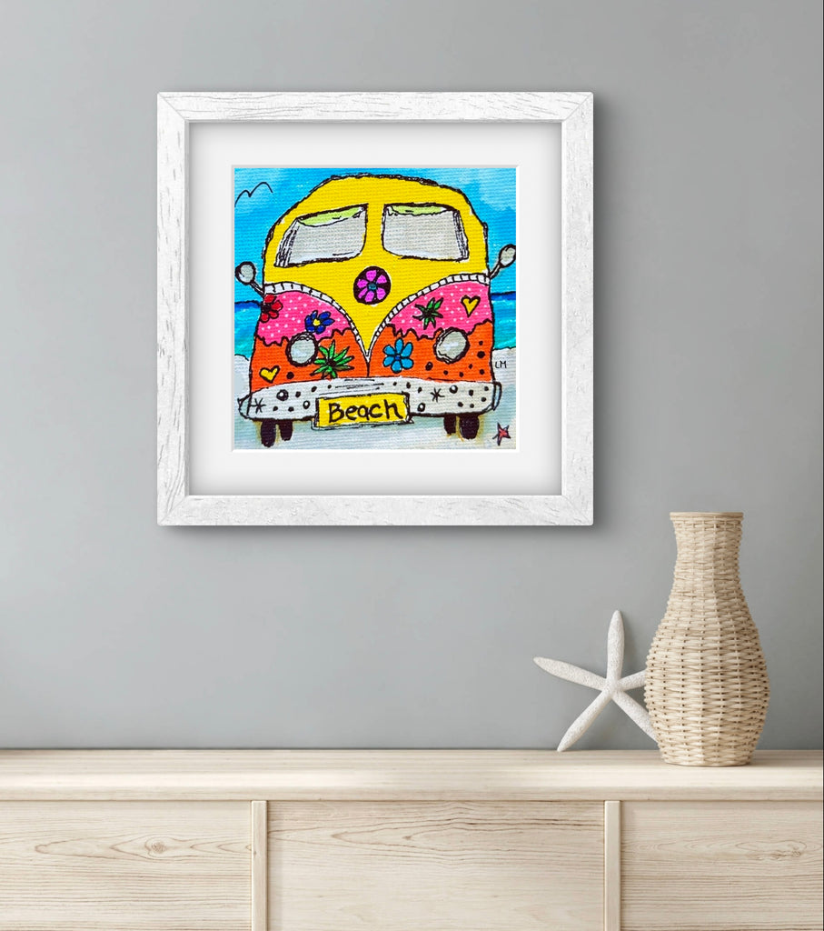 Framed artwork of a colorful van on a beach with a vase and starfish decoration below.