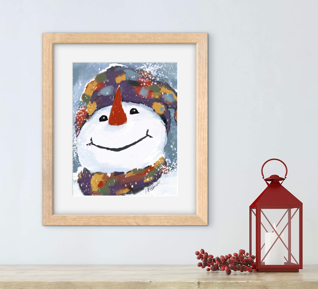 Framed artwork of a snowman with a colorful hat and scarf on a light blue wall, next to a red lantern.