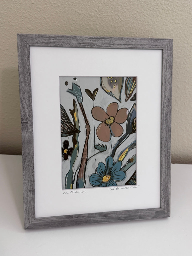 floral art print in a gray frame with a white mat sitting on a white table