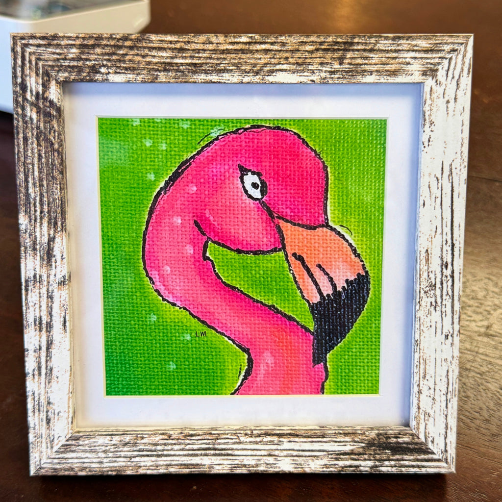Framed artwork of a pink flamingo on a green background