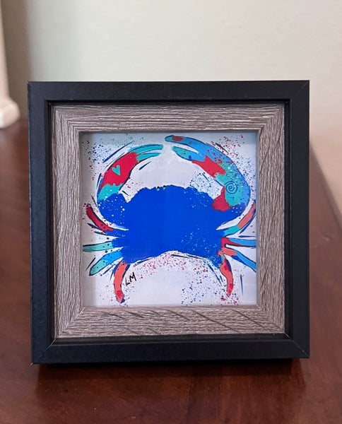 blue crab art in a wood frame sitting on a table top