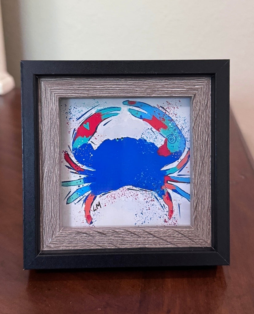 blue crab art in a wood frame sitting on a table top