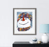 Framed artwork of a colorful snowman on a wall above a black cabinet with decorative items.