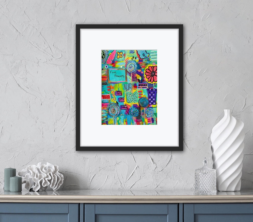 Framed colorful abstract art piece on a gray wall above a white shelf with decorative items.