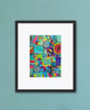 Framed colorful abstract art print on a light blue wall