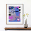 Framed abstract art piece on a wall above a wooden console table with a vase.