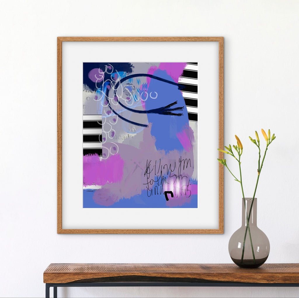 Framed abstract art piece on a wall above a wooden console table with a vase.