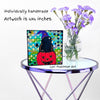 Halloween artwork sitting on a table with a vase of flowers