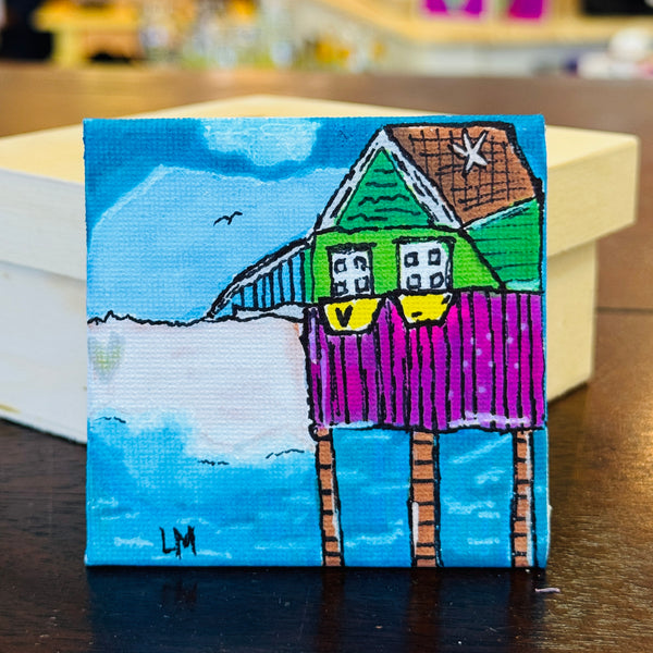 colorful beach house with a heart in the sand
