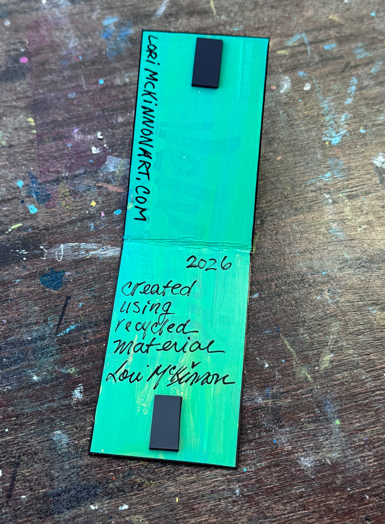 inside a magnetic bookmark that has artist signature and painted green