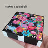 a hand holding a painted wood block with text 'makes a great gift' written above it