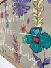 Decorative sign with floral designs and text on a beige background