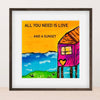 Framed artwork with a colorful house, heart, and text 'All you need is love... and a sunset' on a white background.