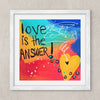 A framed square art print featuring the text 'love is the ANSWER!' in black lettering over a colorful abstract background with blue, yellow, red, and orange tones, plus a large yellow heart and white scribbled line details. The print is shown in a white frame against a light textured wall.