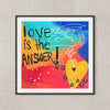 Framed abstract art print on a textured light gray wall. The artwork features the text 'love is the ANSWER!' in black handwritten lettering over a colorful gradient background of blue, yellow, orange, and red, with a large yellow heart and white scribbled lines.
