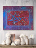 Abstract painting with 'Love' in blue on a colorful background, displayed above a wooden shelf with decorative items.