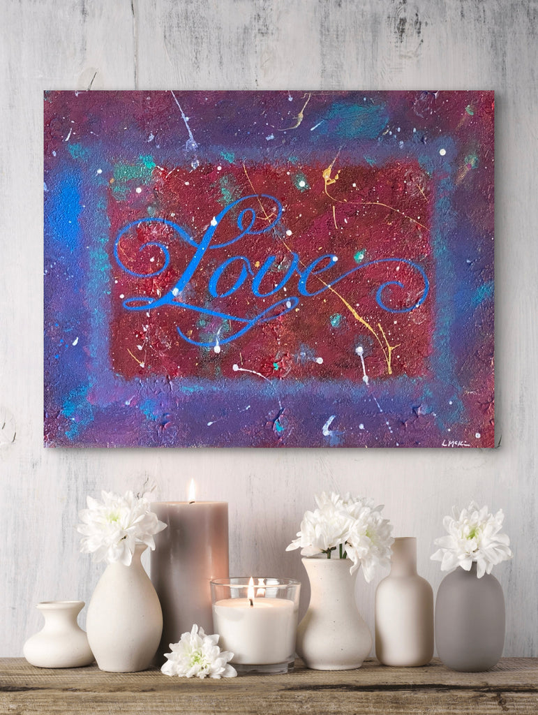 Abstract painting with 'Love' in blue on a colorful background, displayed above a wooden shelf with decorative items.