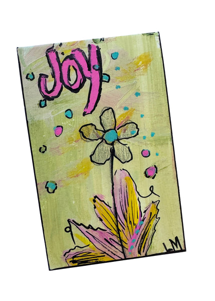 small artwork with a flower and the word joy on it