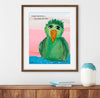 Framed artwork of a green bird with a quote on a wall above a wooden shelf.