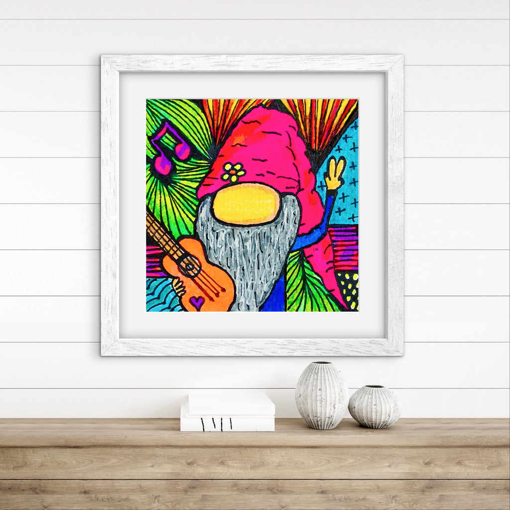 Colorful gnome illustration in a white frame on a wooden surface with a white wall background.