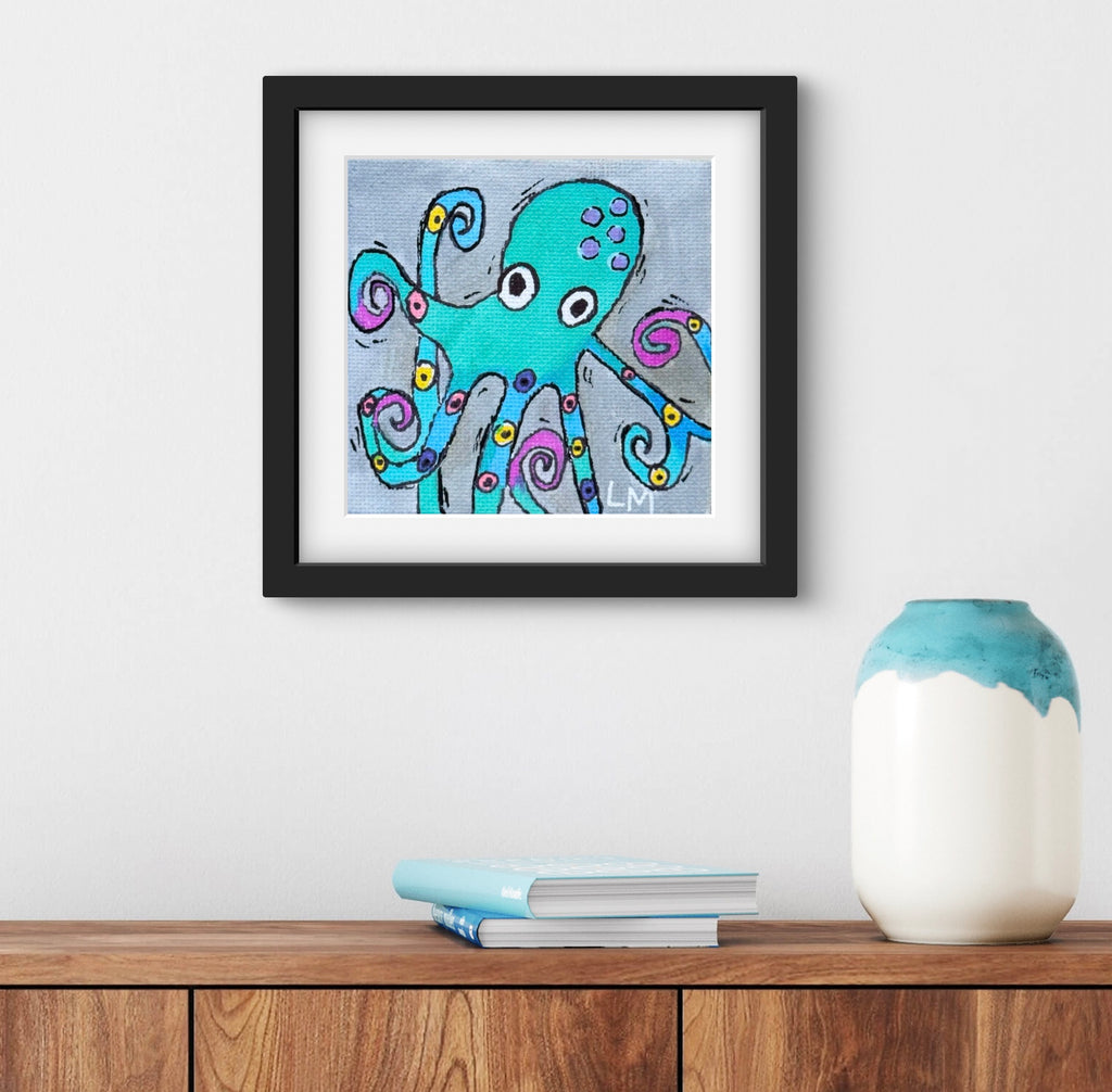 Framed artwork of a colorful octopus on a wall above a wooden surface with a vase and books.