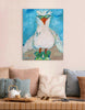 Painting of a bird with sunglasses on a wall above a sofa.