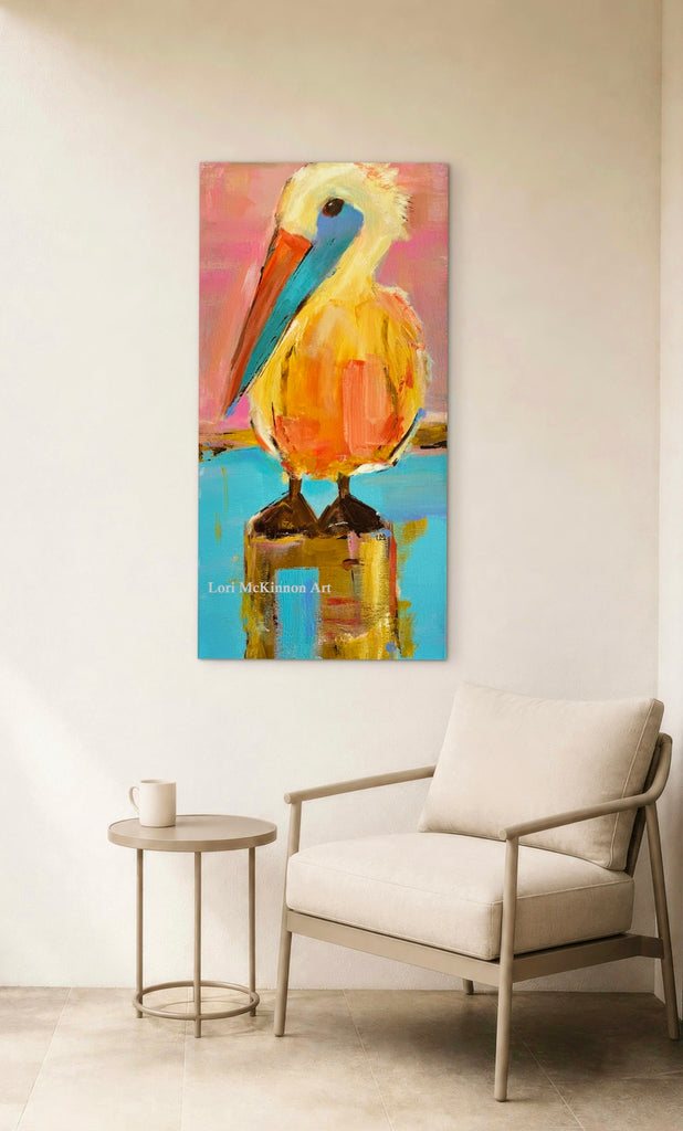 colorful pelican canvas print on a white wall above a chair and a side table with a mug on it