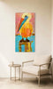 colorful pelican canvas print on a white wall above a chair and a side table with a mug on it