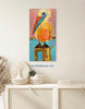 pelican artwork hanging on a white wall above a table with baskets and vases