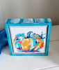 pumpkin artwork in a painted frame on a table next to a trinket dish