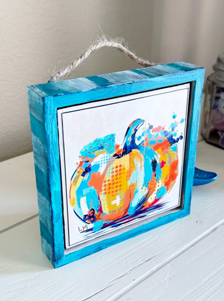 pumpkin artwork in a wood frame painted white and blue with a jute rope hanger or can stand alone on a table
