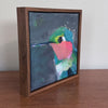 an angled view of a framed painting showing the sides of the frame