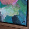 close up of initials on a painting in a brown frame