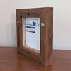 back view of a framed painting with artist signature and showing wire across the back for hanging