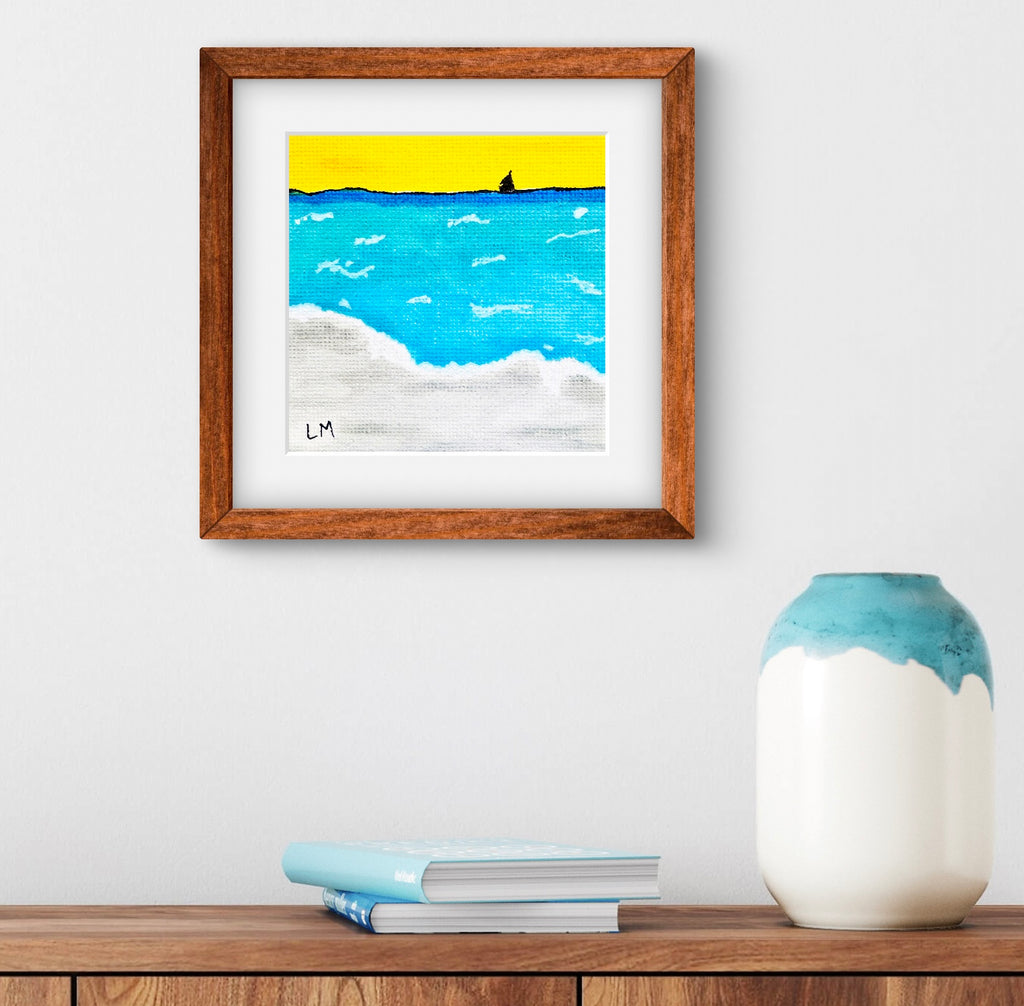 Framed artwork of a seascape with a wooden frame on a white wall above a wooden shelf.