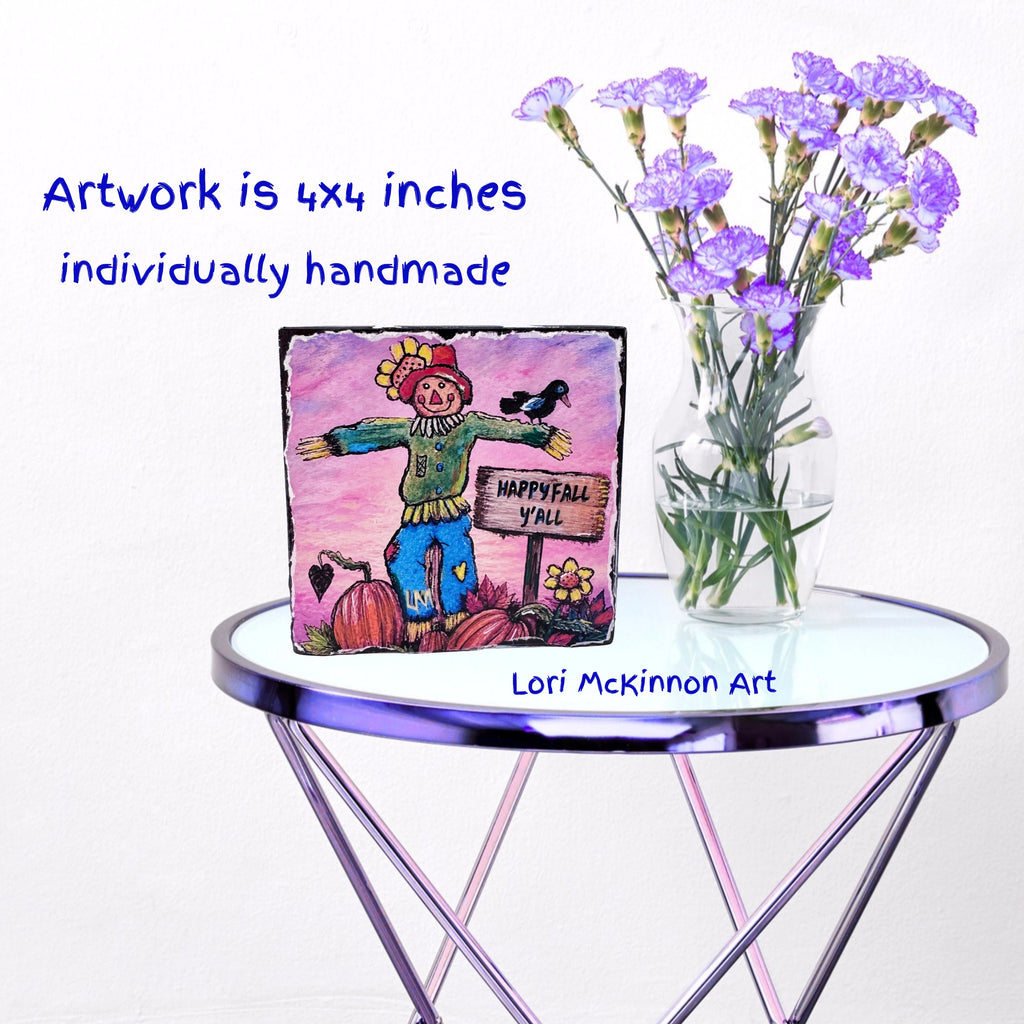 whimsical scarecrow artwork on a table next to a vase of flowers