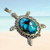 Turtle shaped pendant with turquoise glass center on a gradient background