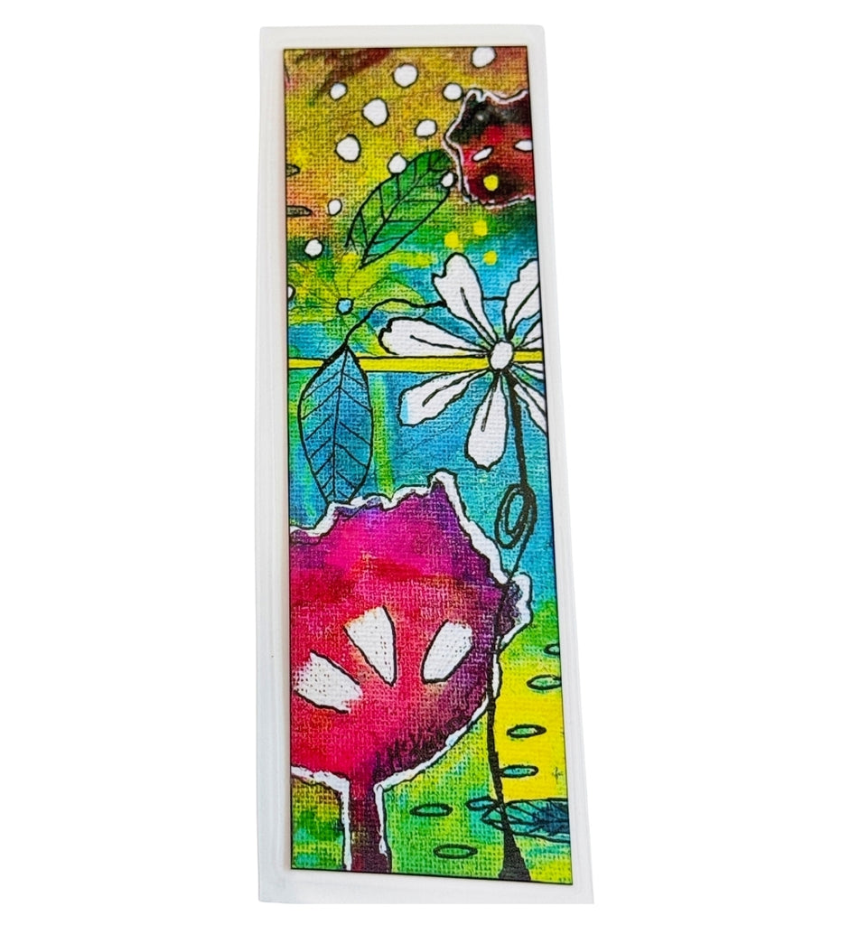 A rectangular bookmark hand painted featuring a colorful abstract floral design with white flowers, green leaves, and pink and yellow elements, presented on a white background.